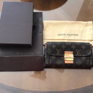 Monogramed LV wallet with buckle fastener.